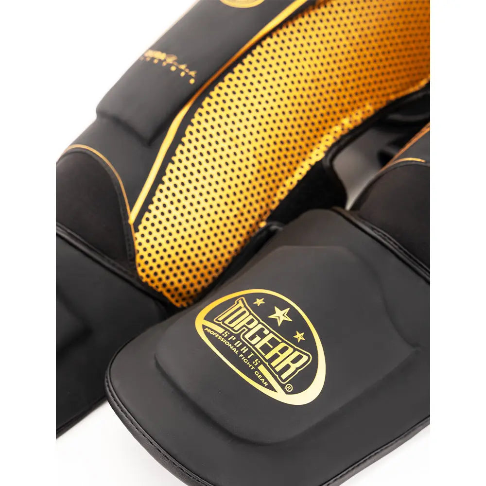 Close-up of Topgear Titan shin guard showing yellow dotted side panel and foot protector logo