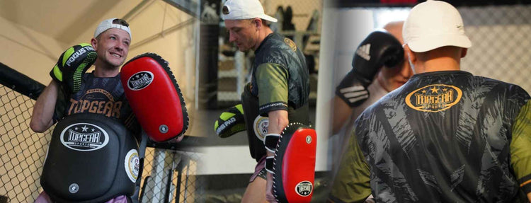 Trainer using red pad and Topgear Sports boxing gloves