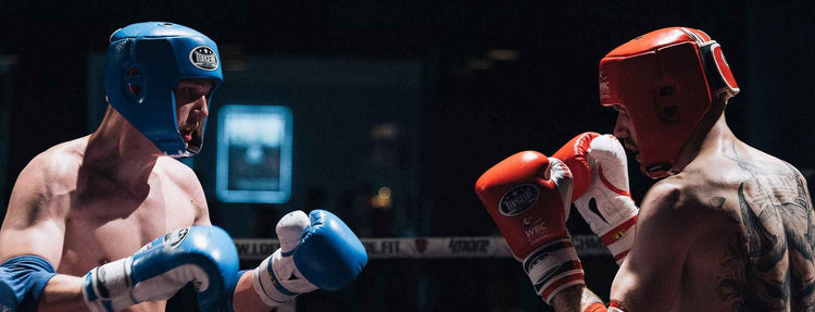Two fighters sparring in the ring wearing Topgear Sports boxing gloves